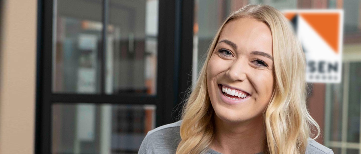 woman smiling at camera in front of andersen logo in showroom