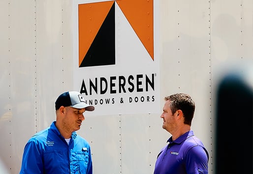 Two men chatting in front of an Andersen Windows truck