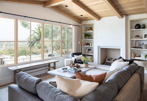 A living room with a couch facing a row of E-Series Picture Windows with white oak frames.