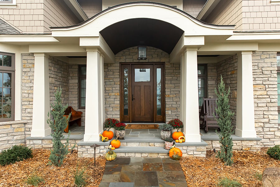 A Craftsman front door made of dark-stained wood with a glass panel in the upper third and sidelights on both sides.