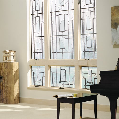 Living space with piano has elegant art glass windows