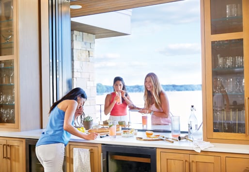 Group of young ladies having a good time with some foor and drinks with a pass-through window from indoor to outdoor