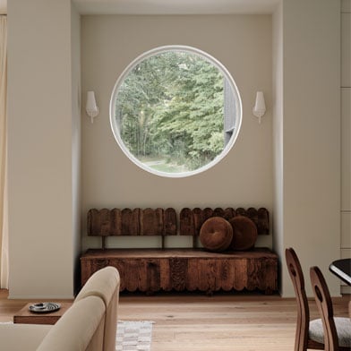 Cozy sitting nook with circle window opening up to the nature outside